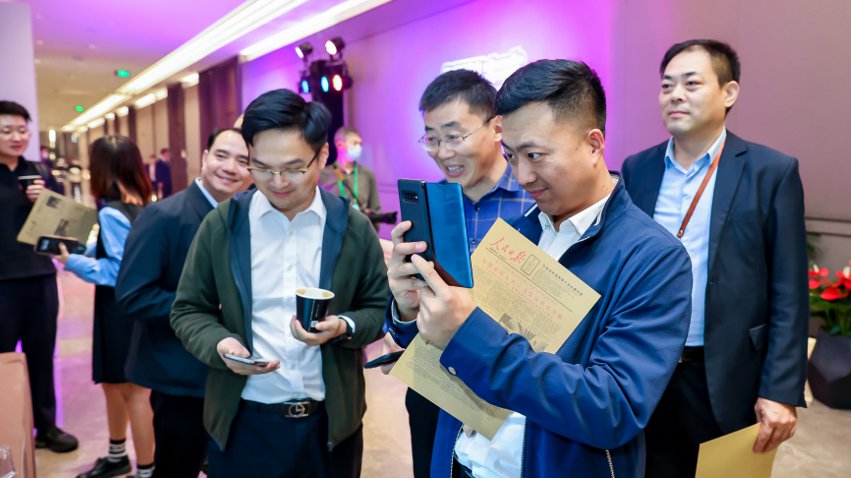 人民網(wǎng)研發(fā)推出的《人民日報(bào)》生日報(bào)吸引嘉賓體驗(yàn)。主辦方供圖